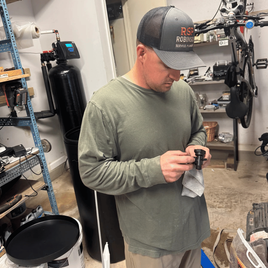 Robinson Service Plumbing inspecting and maintaining a residential water treatment component