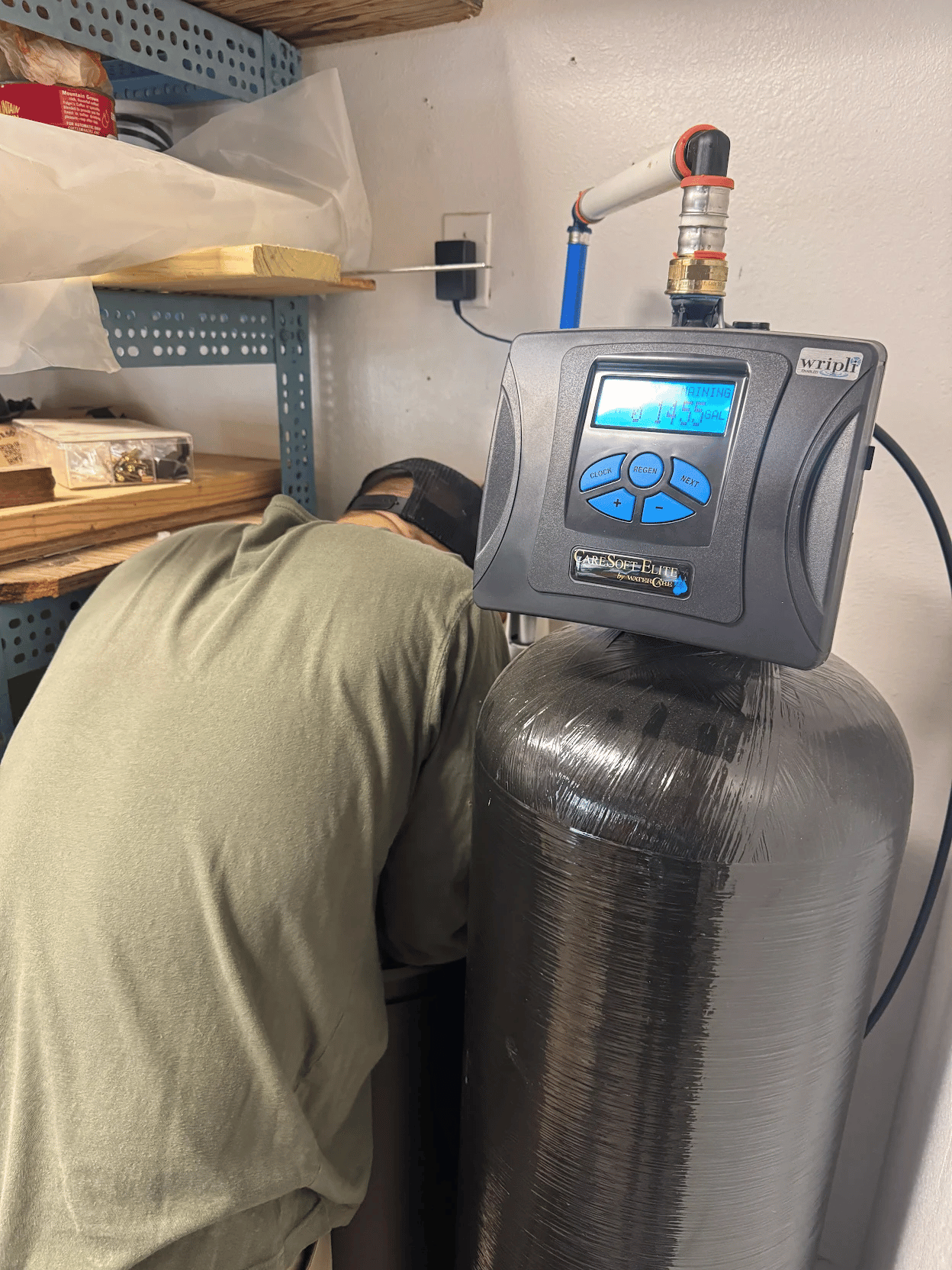 Robinson Service Plumbing technician inspecting and servicing a residential water treatment control system