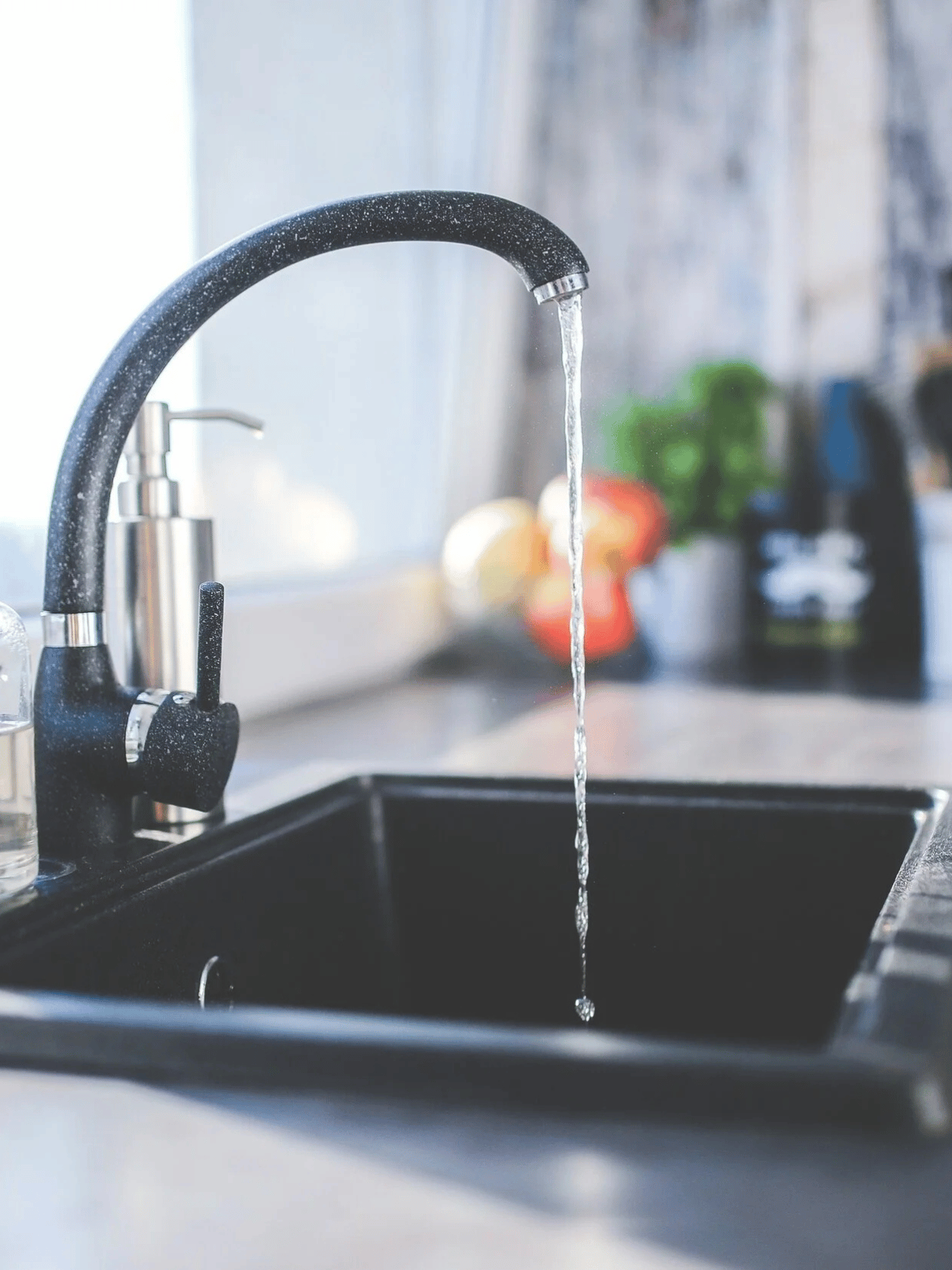 Clear drinking water flowing from a dedicated kitchen faucet for targeted reverse osmosis treatment