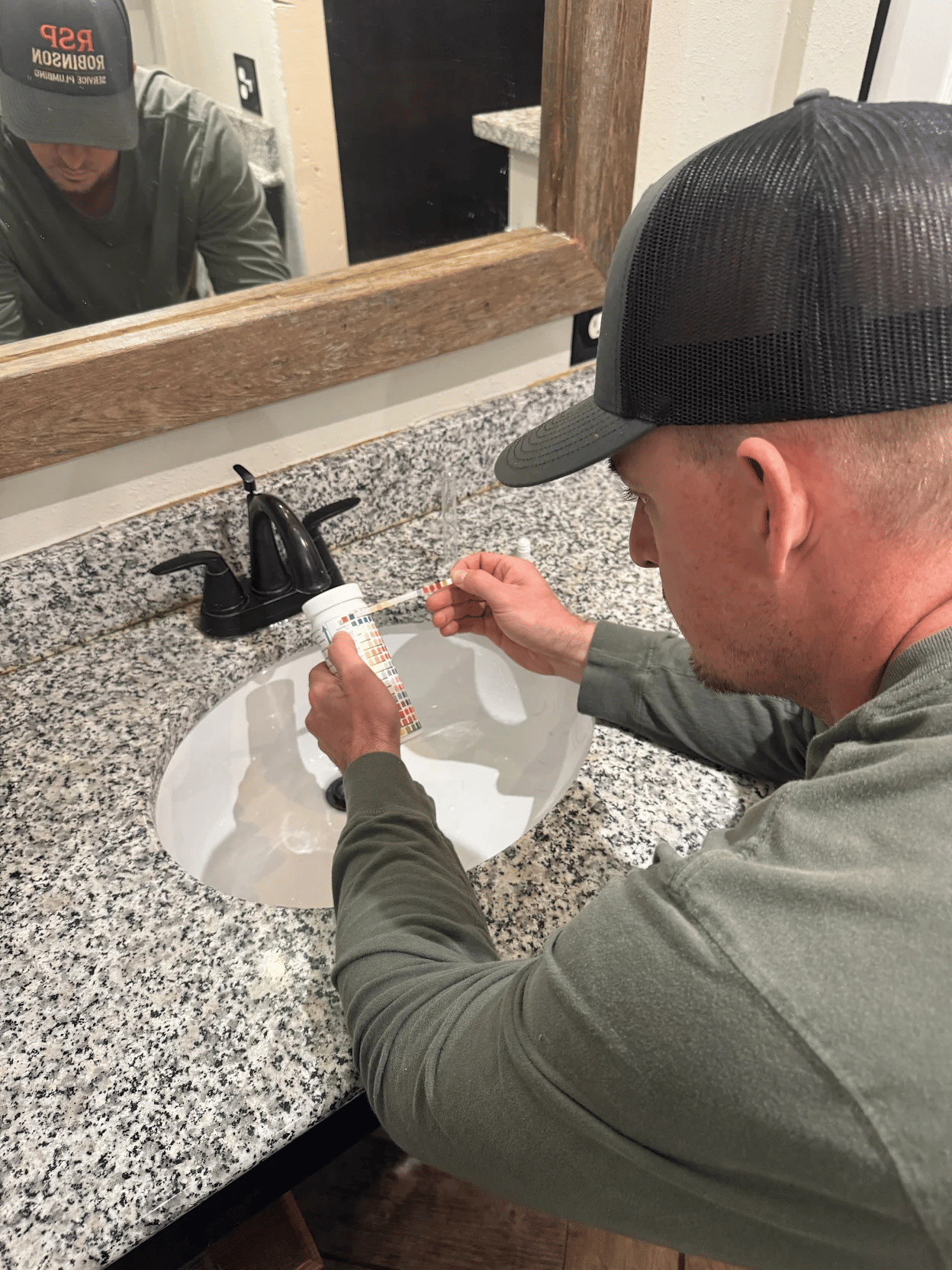 Robinson Service Plumbing technician testing household water in a Bulverde home