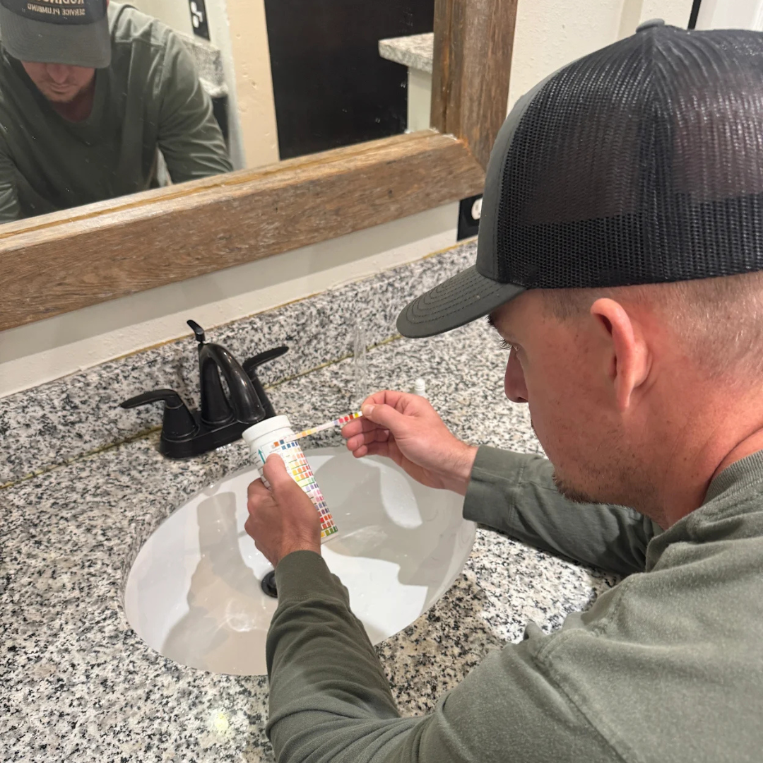Robinson Service Plumbing performing a residential water quality test at a bathroom sink